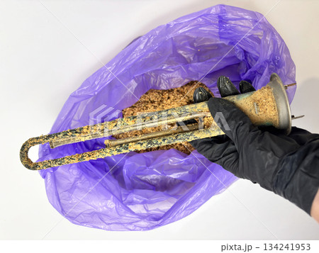 Plumber hand holding a boiler heating element covered with limescale, hard water residue, boiler maintenance and cleaning, scale removal, water heater repair 134241953