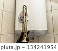 Plumber hand holding a boiler heating element covered with limescale, hard water residue, boiler maintenance and cleaning, scale removal, water heater repair 134241954