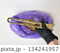 Plumber hand holding a boiler heating element covered with limescale, hard water residue, boiler maintenance and cleaning, scale removal, water heater repair 134241957
