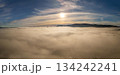 Sun above a sea of fog and clouds with mountain ridge under blue sky, aerial view of foggy mountains 134242241