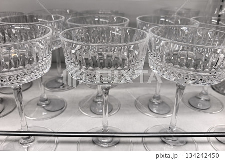 Elegant crystal cocktail glasses showcased in a modern display cabinet 134242450