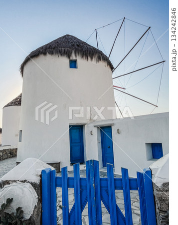Traditional mykonos windmill architecture with vibrant blue details and thatch roof, evoking greek island culture, travel, and famous mediterranean destinations 134242846