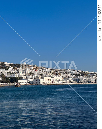 Vertical shot of Mykonos island architecture featuring traditional cycladic whitewashed buildings under a vibrant clear sky 134242853