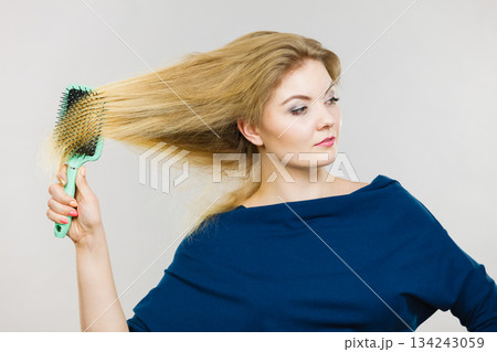 Woman brushing her long hair with brush 134243059