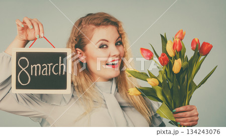 Woman holds tulips, board with text 8 march Woman holds tulips, board with text 8 march 134243076