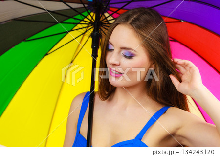 Woman standing under colorful rainbow umbrella Woman standing under colorful rainbow umbrella 134243120