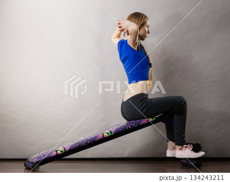 Woman training on bench for sit ups Woman training on bench for sit ups 134243211