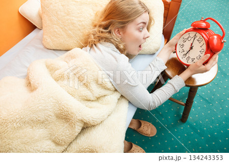 Woman waking up late turning off alarm clock. 134243353