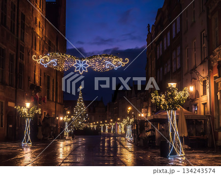 Enchanting Night Street With Christmas Lights, Decorated Trees, And Cozy Outdoor Cafes In Old Town, Gdansk, Poland 134243574