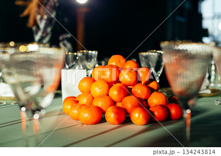 Centerpiece of stacked tangerines on a luxury banquet table 134243814