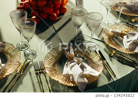 Top-down view of luxury table setting with gold charger plates and napkin rings Top-down view of luxury table setting with gold charger plates and napkin rings 134243822
