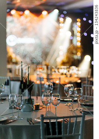 Wide view of banquet hall with tables, chairs, and stage lighting Wide view of banquet hall with tables, chairs, and stage lighting 134243836