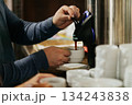 Man pouring coffee from a dispenser into a cup 134243838
