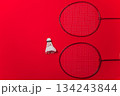Two Red Badminton Rackets And A White Shuttlecock Arranged On A Vibrant Red Background 134243844