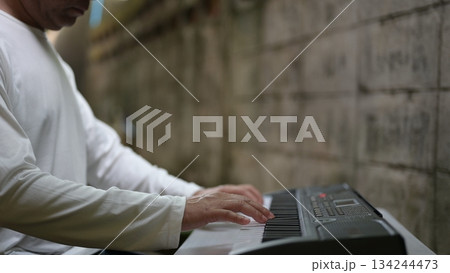 Modern Musicians Hands On Electronic Keyboard Closeup In White Shirt Against Concrete Wall Background Modern Musicians Hands On Electronic Keyboard Closeup In White Shirt Against Concrete Wall Background 134244473