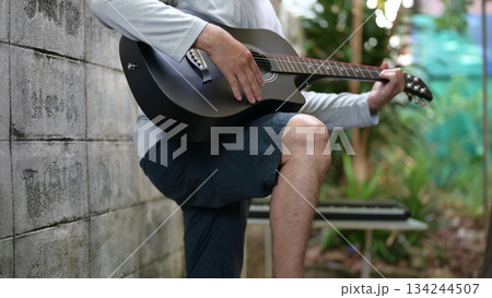 Acoustic Guitar Serenade Outdoor Musicians Hand Mastering Six String Body, Against Weathered Wall Effect 134244507