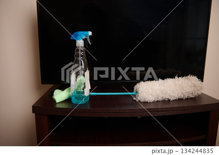Cleaning Supplies on TV Stand With Spray Bottle, Microfiber Roller, and Cloth 134244835