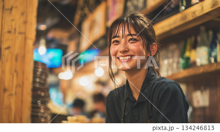 居酒屋で笑顔で働く大学生アルバイトの楽しそうな仕事風景 134246813