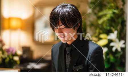 葬儀場で落ち着いた対応を行う男性スタッフのプロの姿 134246814