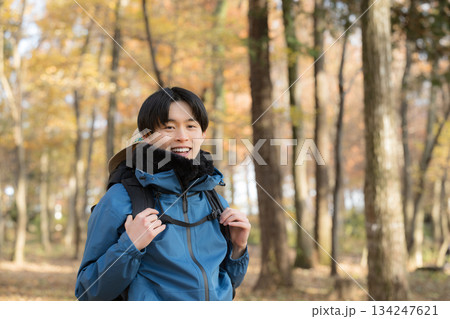 秋冬の紅葉の山を登山をする若い男性カメラ目線 アウトドアのお出かけやレジャーのイメージ 秋冬の紅葉の山を登山をする若い男性カメラ目線 アウトドアのお出かけやレジャーのイメージ 134247621