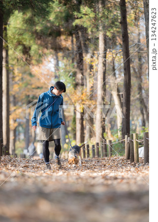 秋の公園で犬と散歩を楽しむ男性の笑顔とペットとの時間の全身	 134247623