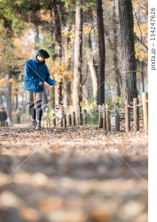 秋の公園で犬と散歩を楽しむ男性の笑顔とペットとの時間の全身 秋の公園で犬と散歩を楽しむ男性の笑顔とペットとの時間の全身 134247626