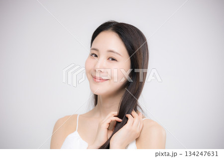 美容ポートレート、ストレートのロングヘアの髪の毛の手入れをする美しい髪と横顔の女性　カメラ目線 134247631