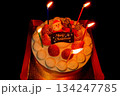 クリスマスケーキのロウソクに火を灯したホールケーキ 134247785