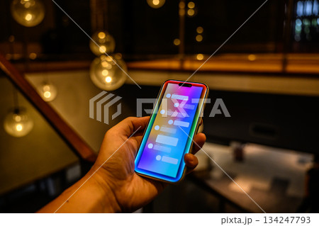 夜のカフェでスマホでチャット 134247793