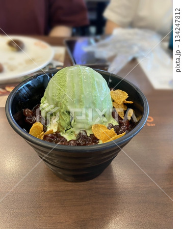 Refreshing matcha bingsu with fluffy shaved ice, rich green tea flavor, sweet red beans, and chewy rice cakes. A perfect balance of earthy, creamy, and sweet flavors for a delightful dessert! 134247812