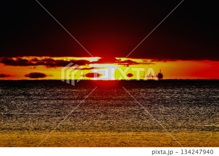 黒い雲から出て来てダルマ夕日に 134247940