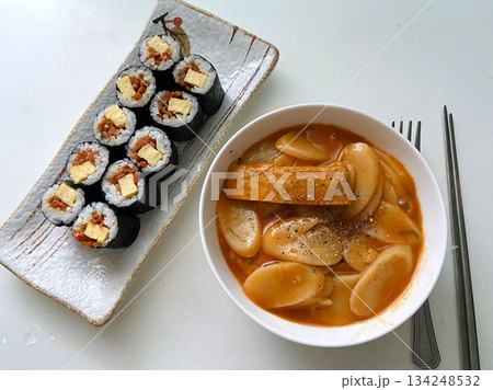 Spicy and chewy tteokbokki paired with fresh and flavorful kimbap rolls filled with rice, vegetables, and protein. A perfect Korean street food combination for a satisfying meal. 134248532