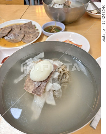 Authentic Pyongyang naengmyeon with chewy buckwheat noodles in cold, clear broth, offering a refreshing and delicate flavor. Perfect for traditional Korean cuisine menus and summer dishes. 134248546