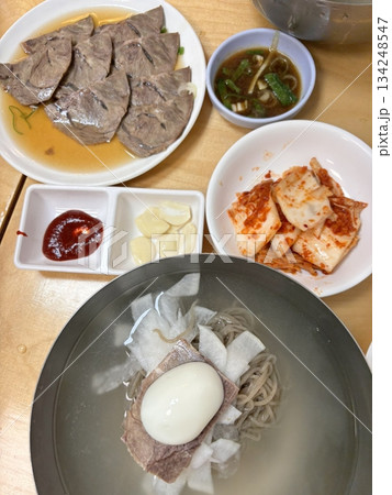 Authentic Pyongyang naengmyeon with chewy buckwheat noodles in cold, clear broth, offering a refreshing and delicate flavor. Perfect for traditional Korean cuisine menus and summer dishes. 134248547