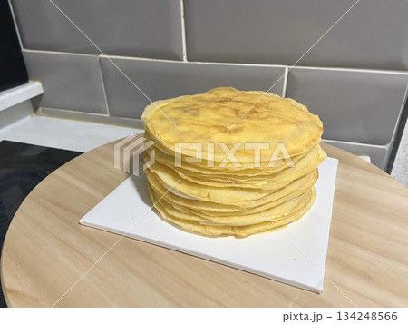 Thin crepes with soft, golden surface and slightly crisp edges, folded neatly to showcase their delicate texture, warm color, and light airy appearance in close-up detail Thin crepes with soft, golden surface and slightly crisp edges, folded neatly to showcase their delicate texture, warm color, and light airy appearance in close-up detail 134248566