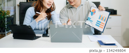 Two business workers talking on the smartphone and using laptop 134249804