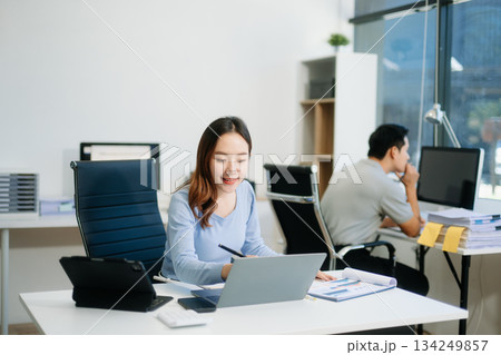 Asian business woman typing laptop and tablet Placed at the table at the office 134249857