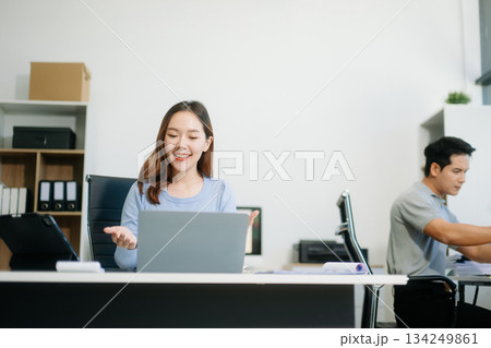 Asian business woman typing laptop and tablet Placed at the table at the office Asian business woman typing laptop and tablet Placed at the table at the office 134249861