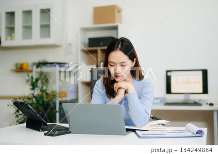 Asian woman feeling migraine head strain.Overworked businesswoman financier while working Asian woman feeling migraine head strain.Overworked businesswoman financier while working 134249884