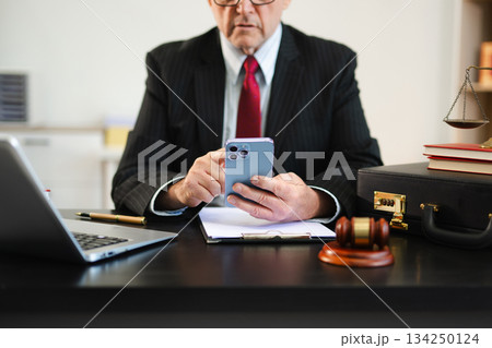 justice and law concept. Male judge in a courtroom the gavel, working with smart phone and laptop and digital tablet justice and law concept. Male judge in a courtroom the gavel, working with smart phone and laptop and digital tablet 134250124