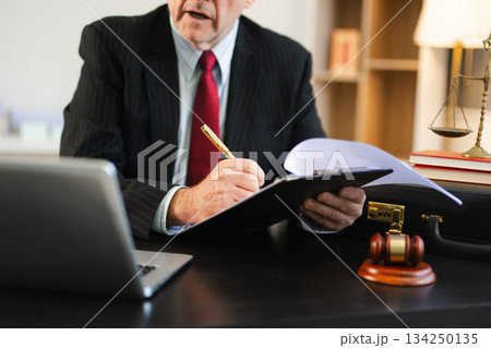 justice and law concept. Male judge in a courtroom the gavel, working with smart phone and laptop and digital tablet justice and law concept. Male judge in a courtroom the gavel, working with smart phone and laptop and digital tablet 134250135