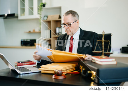 Male judge in courtroom, lawyer working in office. Perfect for business, legal advice, corporate law, and professional consulting themes. Male judge in courtroom, lawyer working in office. Perfect for business, legal advice, corporate law, and professional consulting themes. 134250144