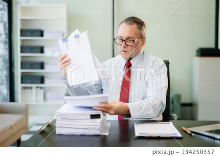 Professional businessman working at office with laptop, tablet, and notes. Perfect for business, finance 134250357