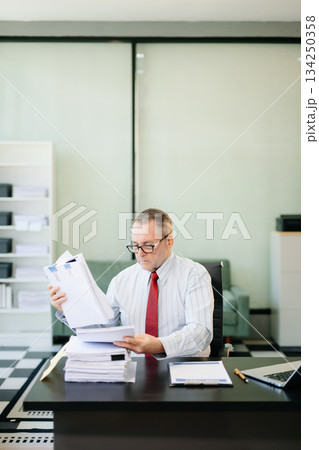 Professional businessman working at office with laptop, tablet, and notes. Perfect for business, finance 134250358