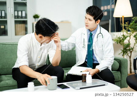 Doctor consulting with a stressed male patient in private clinic. Mental health care, therapy, empathy, and emotional support Doctor consulting with a stressed male patient in private clinic. Mental health care, therapy, empathy, and emotional support 134250527