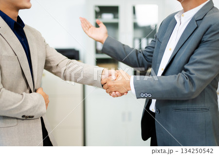 Professional handshake between two businessmen sealing a successful agreement in a modern office Professional handshake between two businessmen sealing a successful agreement in a modern office 134250542