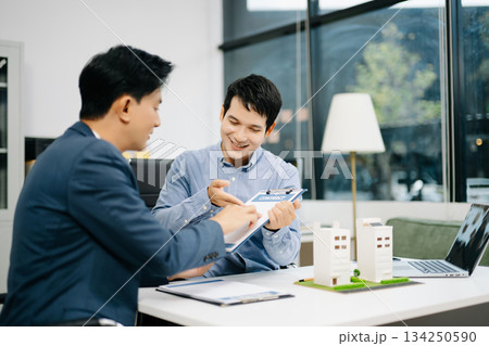 Real estate broker consults with customer signing contract agreement at office. Business deal, insurance decision Real estate broker consults with customer signing contract agreement at office. Business deal, insurance decision 134250590
