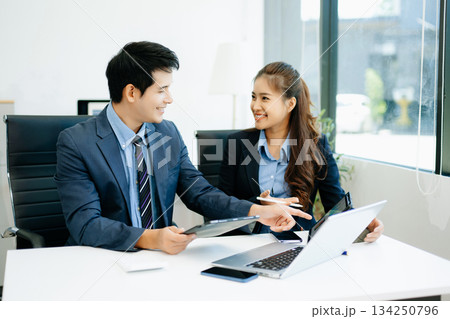 Businesswomen work and discuss their business plans. A Human employee explains and shows her colleague the results paper Businesswomen work and discuss their business plans. A Human employee explains and shows her colleague the results paper 134250796