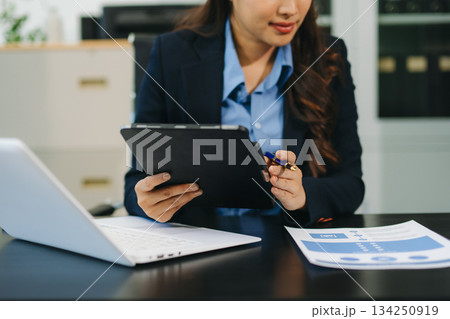 Businesswoman utilizing smartphone and tablet technology. Perfect for corporate, technology, and modern business visuals Businesswoman utilizing smartphone and tablet technology. Perfect for corporate, technology, and modern business visuals 134250919