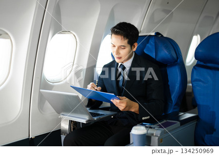 Confident businessman making a phone call in first class, blending luxury air travel with business, technology, and global networking opportunities. Confident businessman making a phone call in first class, blending luxury air travel with business, technology, and global networking opportunities. 134250969